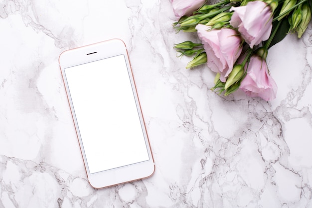 Mobile phone with pink flowers on marble 