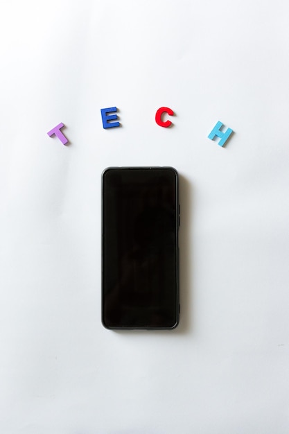 Мобильный телефон со словом tech цветными буквами на белом фоне
