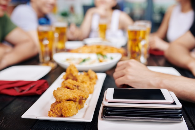 Mobile phones with fast food on the table in cafe