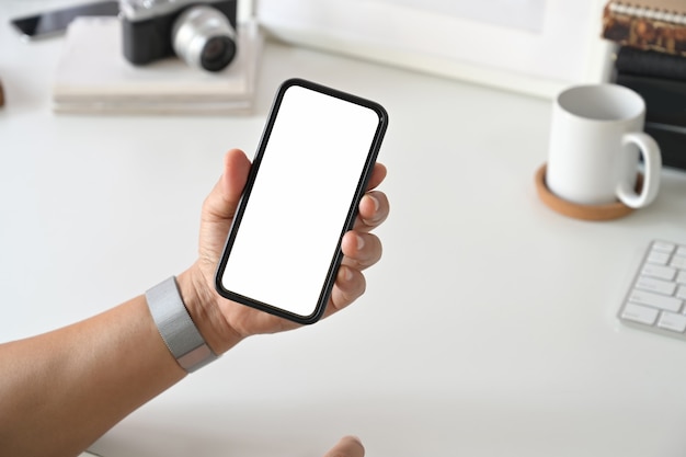 Mobile smart phone in man's hand at desk work.