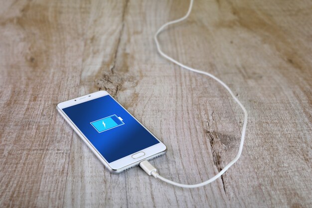 Mobile smart phones charging on wooden desk