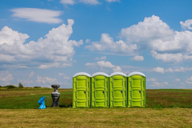 Toilette mobile. toilette portatile sull'erba su uno sfondo di nuvole.