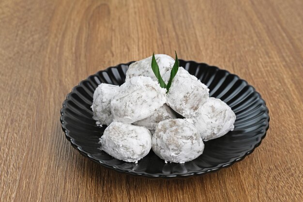 Mochi dessert served on black plate on wooden board Selected focus