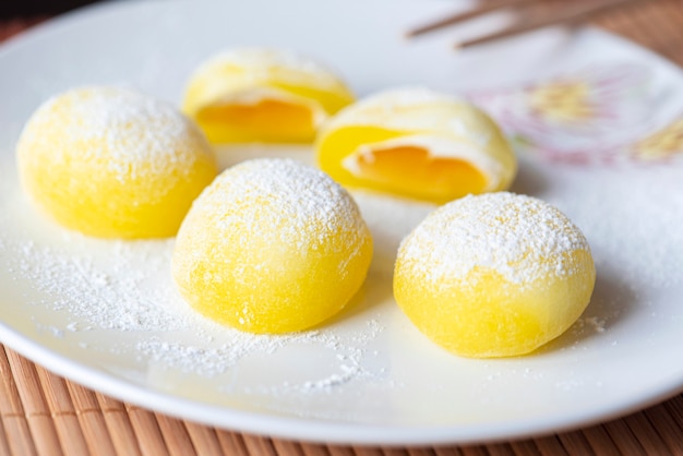 白いお皿に餅。黄米のデザート、もちは主に日本の伝統的な甘い食べ物です