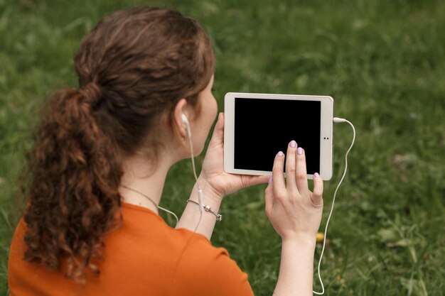 Mock-up afbeelding van vrouw die tablet gebruikt