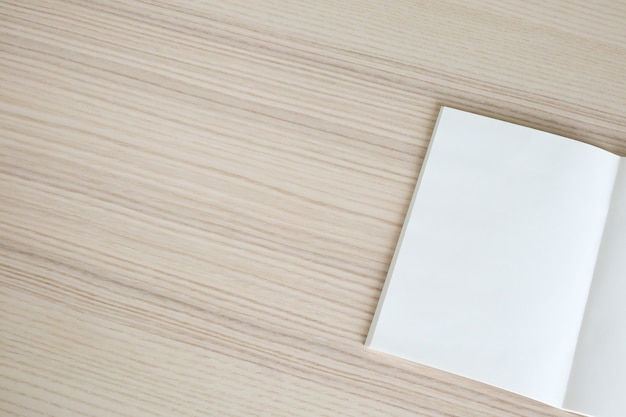 Mock up blank open paper book on wood table background