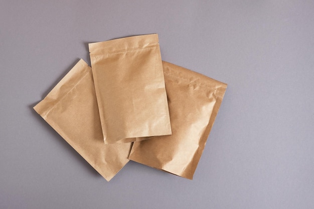 Макет пустой бумажный пакет на сером фоне Экологически чистая упаковочная бумага перерабатывает ноль отходов