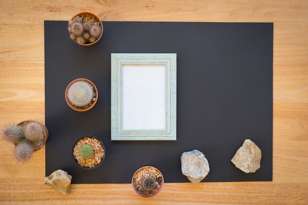 Photo mock up of blank photo frame with cactus on wood background