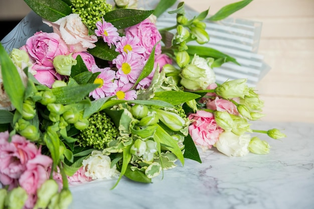 Mock up bouquet of roses daisies lisianthus chrysanthemums unopened buds on tablewhite freesias carn