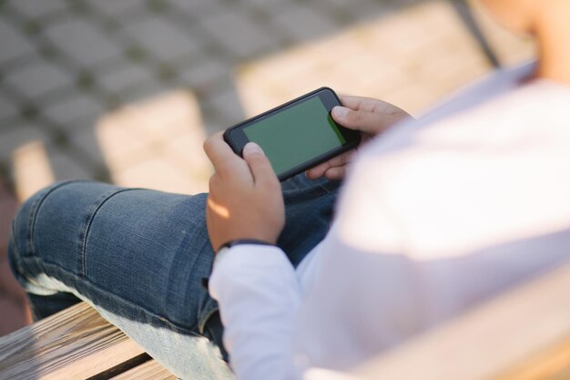 Mock up of boy play games on the smartphone Bay hold phone horizontally Green screen