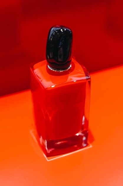 Mock up bright red glass perfume bottle on a stand