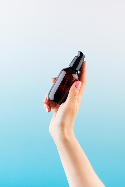 Photo a mock-up of a brown dispenser with a natural cosmetic product in a womans hand