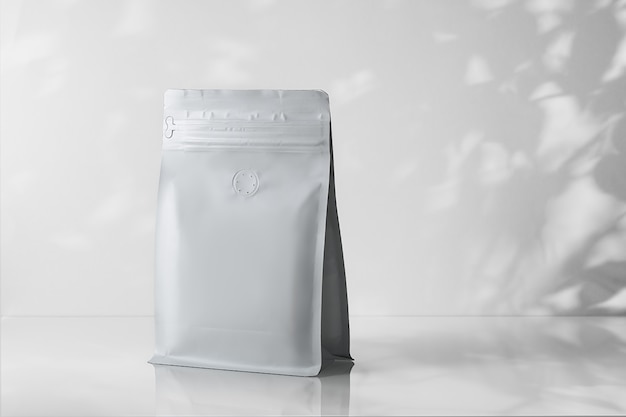 Mock-up of a coffee package on a gray background with stiff
shadows from the leaves.