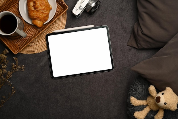 Mock up digital tablet with empty screen teddybear and camera on gray carpet