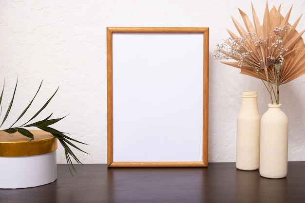 Mock up empty wooden vertical frame mockup dried palm leaves in vases on white background interior h