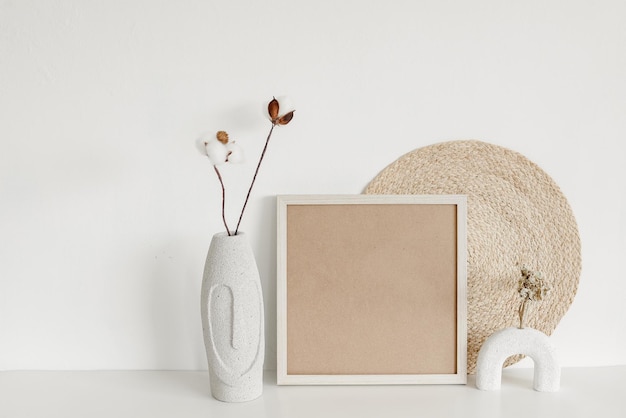 Mock up frame dry plant on vase and wicker Minimalist home interior background in warm tone