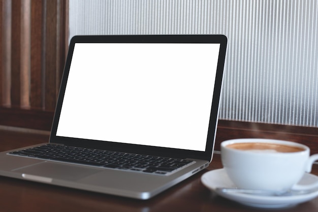 Photo mock up image of blank screen of laptop computer with cup on coffee on wooden table