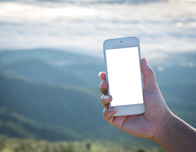 Mock up immagine della mano della donna che tiene smartphone bianco con schermo bianco vuoto