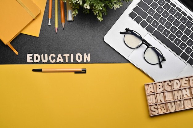 Mock up laptop computer eyeglasses and stationery on yellow and black background