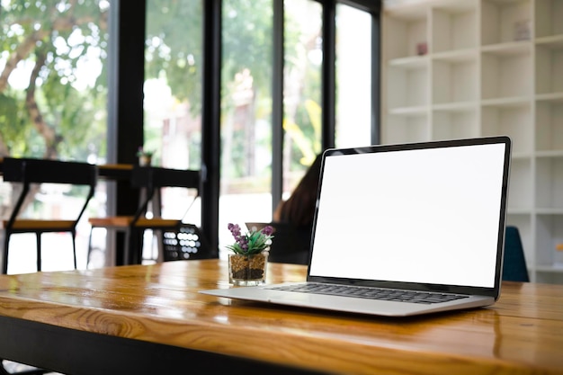 Mock up laptop computer with empty display on wooden table