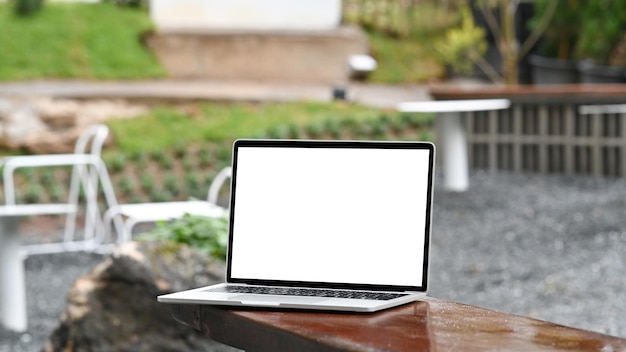 Mock up computer portatile con display wie su un tavolo di legno in giardino