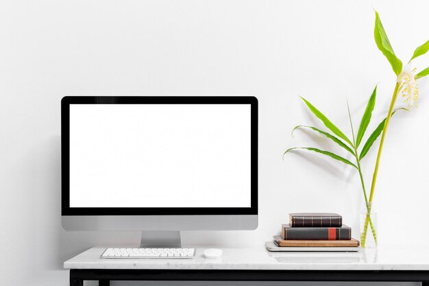 Mock up laptop with supplies and plant on marble desk table.