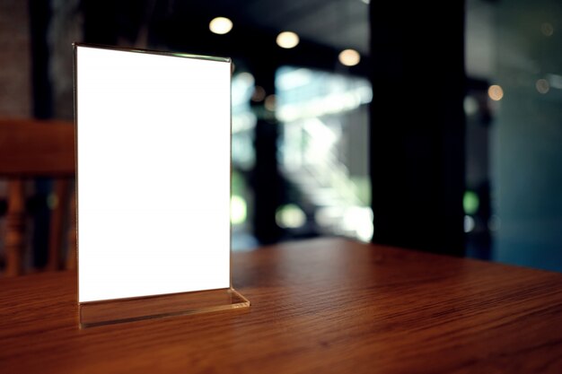 Mock up Menu frame standing on wood table in Bar restaurant cafe. space for text.