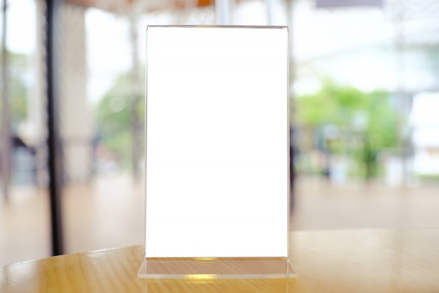 Mock up Menu frame standing on wood table in Bar restaurant cafe. space for text