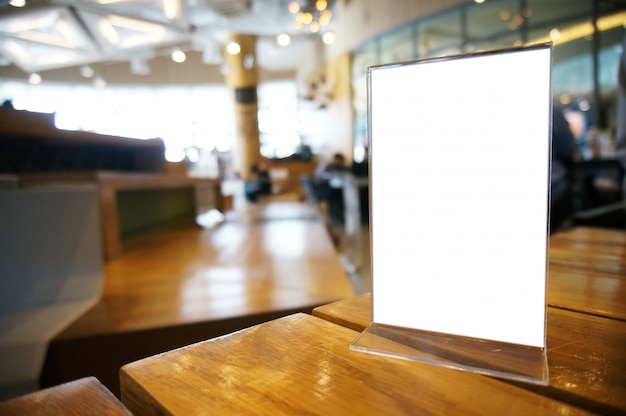 Mock up Menu frame standing on wood table in Bar restaurant cafe. space for text.