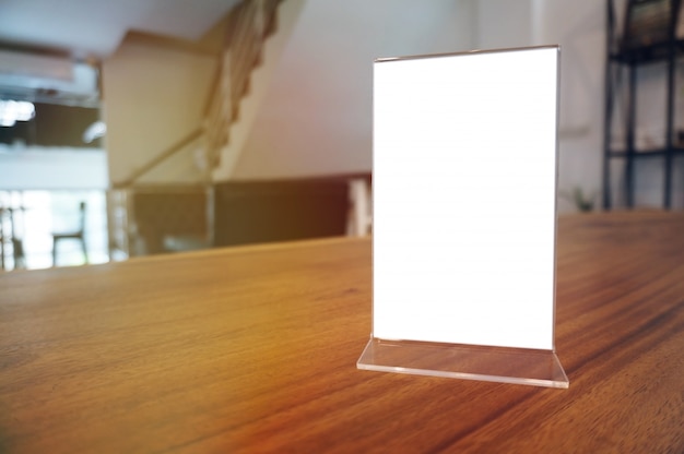 Mock up Menu frame standing on wood table in Bar restaurant cafe. space for text.