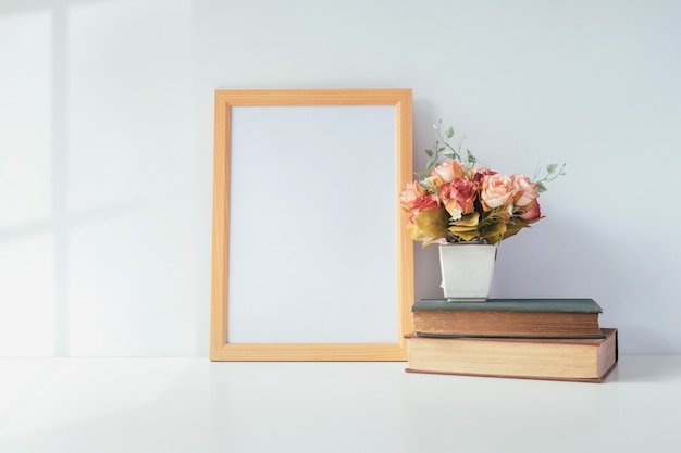 Mock up portrait photo frame with green plant on table, home decoration.