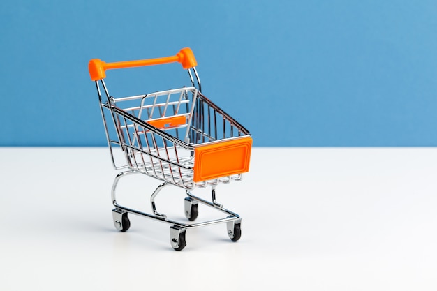 Mock up shoppong online cart on desk table office soft blue wall