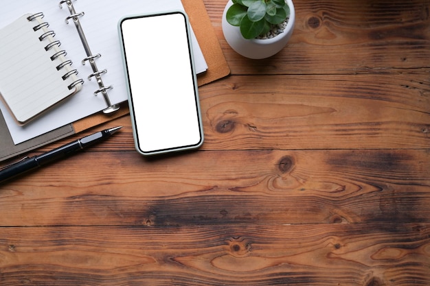 Mock up smart phone with blank screen on wooden table