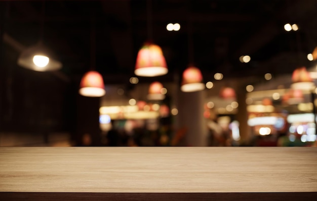 Mock up for space Empty dark wooden table in front of abstract blurred bokeh background of restaurant can be used for display or montage your product