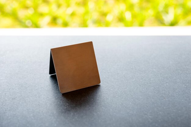 Mock up stainless menu frame, empty table tent stand on the table in restaurant