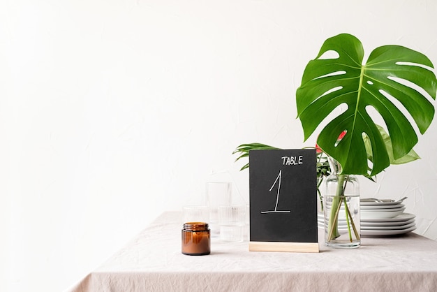 Mock up table tent with words table 1 on restaurant table with tropical bouquet. tenda da tavolo in gesso nero