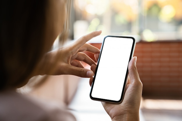 Mock-up telefoon in vrouwenhand met wit scherm