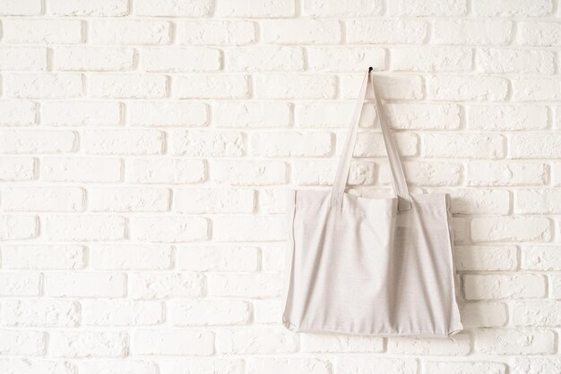 Mock up Tote bag eco hipster white cotton fabric on white brick wall background