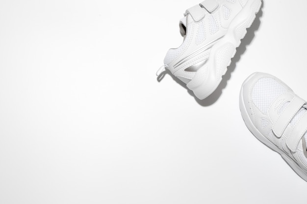 Mock up two white running shoes on the side with free space for text isolated on a white background