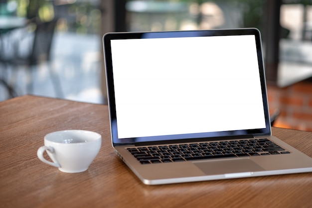 空白のスクリーンコンピューターとラップトップを使用して近代的なコーヒーショップのワークスペース