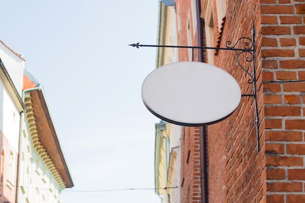 Photo mock up of a white blank empty oval vintage circle for cafe, restaurant name and logo, in an old town city