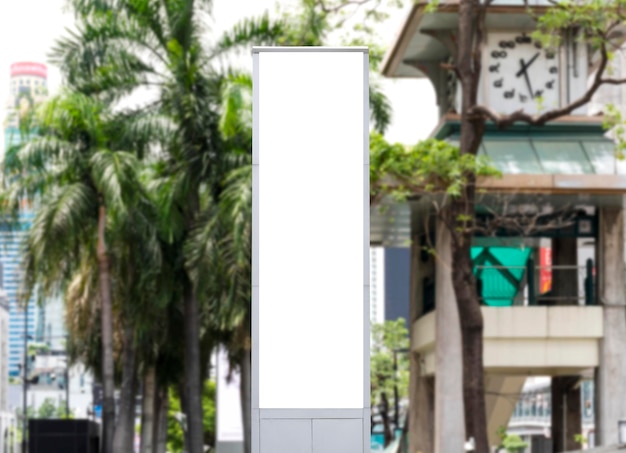 モックアップ用の都市景観ビューのクリッピングパスを備えたタワーポール上の白い LED ディスプレイ垂直看板をモックアップします。