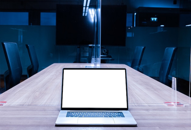 Mock up white screen display laptop on table in meeting room