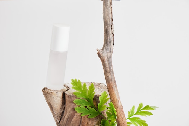 Mock up witte lege parfumfles met houten log, droge bloemen voor cosmetica op grijze achtergrond.