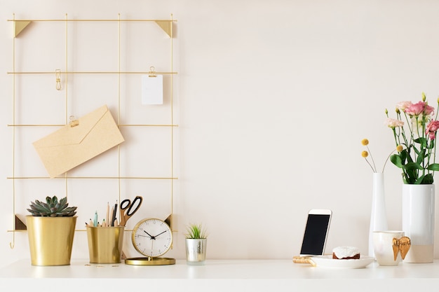 Mock up of woman workplace on light background. Business office desk with golden colors. Modern design. Minimal style.