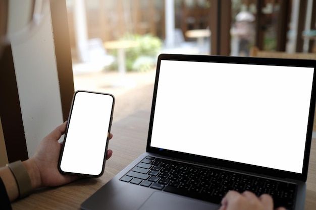 Foto mockup afbeelding computer, mobiele telefoon leeg scherm voor het typen van tekst met de hand, met behulp van laptop contact zakelijke informatie zoeken op de werkplek op bureau op office.design creatieve werkruimte op houten bureau