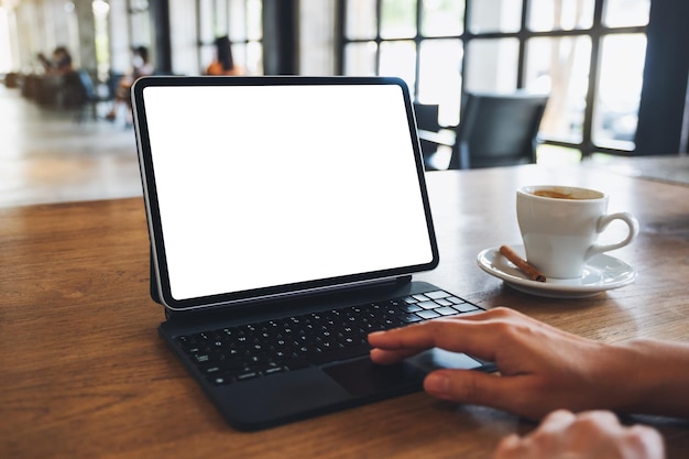 Mockup-afbeelding van een vrouw die digitale tablet-touchpad gebruikt en aanraakt met een leeg wit bureaubladscherm in café