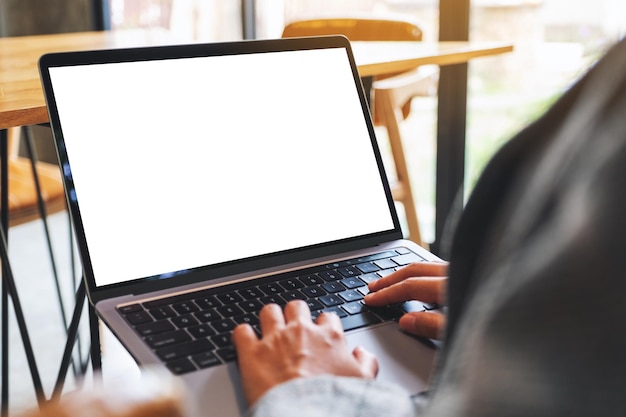 Mockup-afbeelding van een vrouw die een laptop gebruikt en typt met een leeg wit desktopscherm