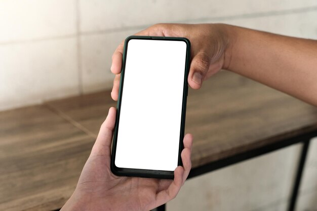 Foto mockup-afbeelding van een vrouw die een mobiele telefoon met een leeg wit scherm aan iemand laat zien