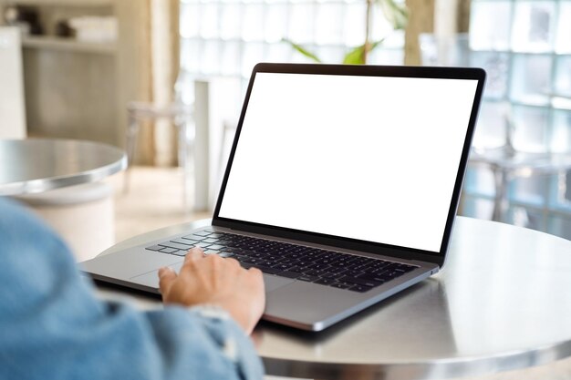 Mockup-afbeelding van een vrouw die het touchpad van een laptopcomputer gebruikt en aanraakt met een leeg wit desktopscherm